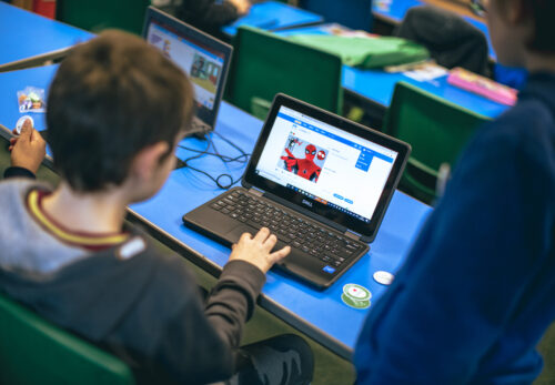 A child codes a Spiderman project at a laptop during a Code Club session.