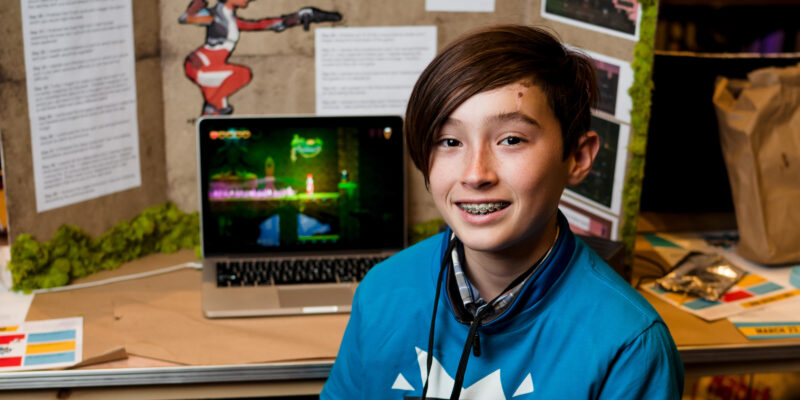 A young coder shows off their tech project for Coolest Projects.