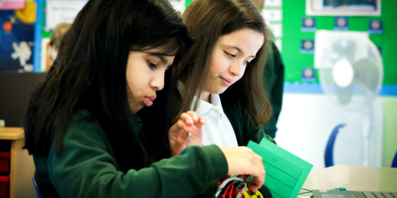 Two learners do physical computing in the primary school classroom.