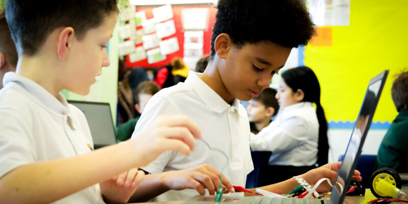Two learners do physical computing in the primary school classroom.